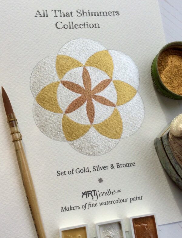 Image shows a mandala painted in gold, silver and bronze. the light is refected in the paint. a paint brush lays to the side of the mandala. the words Art Scribe, makers of fine watercolour paint is printed underneath the mandala.